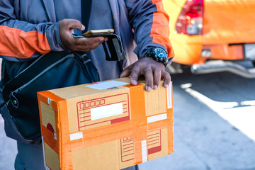 Young modern delivery man using smartphone on delivery work time.