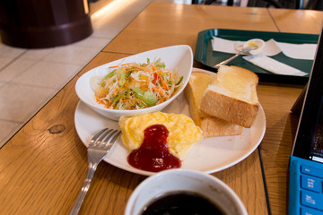 Omelette/salad/bread and coffee and laptop - moment of breakfast at cafe in the morning in Tokyo, Japan