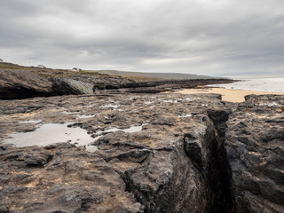 Fototapeta na wymiar West coast of Ireland, stone formation, cloudy day, low tide. County Clare, Ireland.