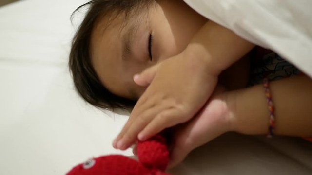 Asian little child are thumb sucking as sleeping in the bedroom. Health care concept.