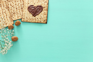 Pesah celebration concept (jewish Passover holiday) with chocolate heart over matzah. Top view flat lay