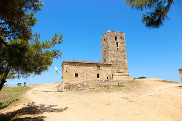 Naklejka premium view of ancient church and ancient byzantine tower in Nea Fokea, Greece surrounded by pines