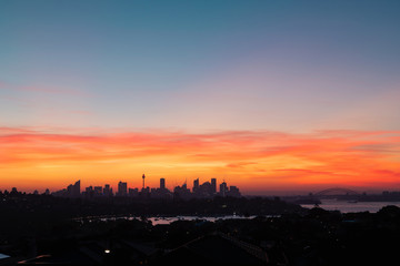 Sydney skyline with red orange sunset sky.