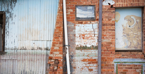 Old run down wall made of bricks and corrugated iron