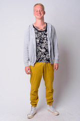 Fototapeta premium Full body shot of happy young man with blond hair smiling