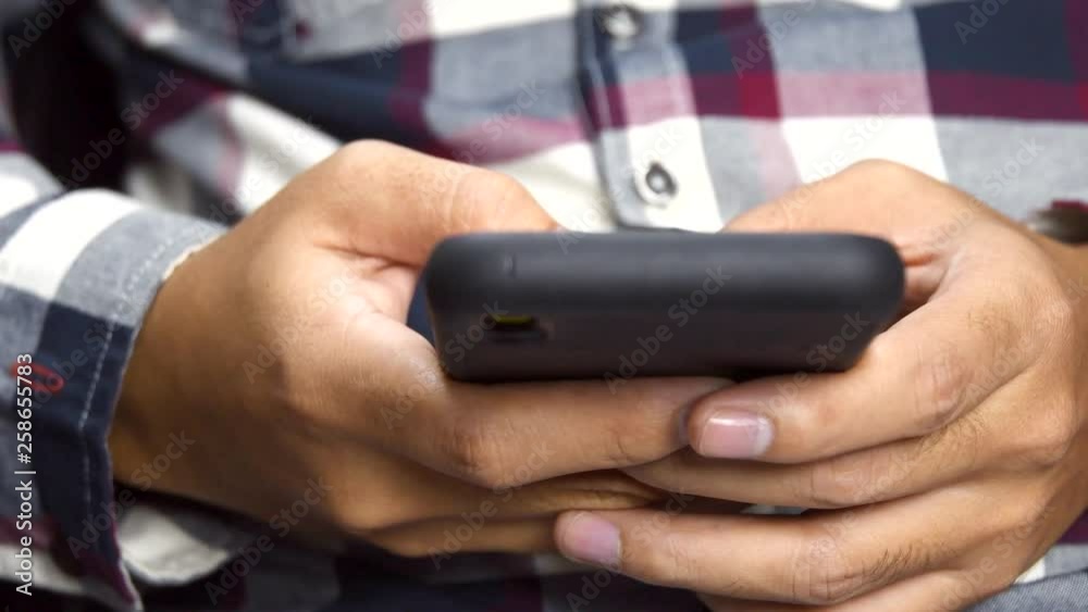 Poster closeup of hands of a man touching on the smartphone. 4k resolution