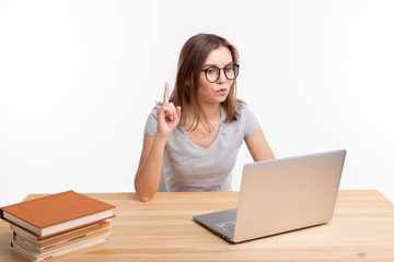 Study, education and people concept - young woman nerd is learning exercises using laptop