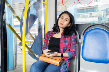 Female passenger falling asleep on the bus seat
