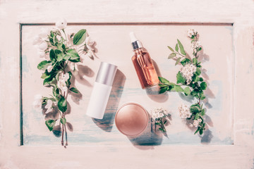 Natural organic cosmetics: serum, cream, mask on wooden background with flowers. Skincare concept - obrazy, fototapety, plakaty