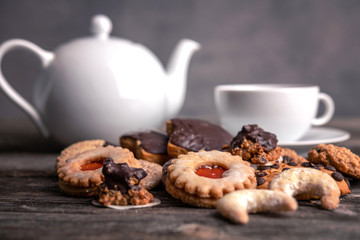 different homemade cookies with cup and pot of tea