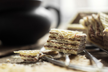 Sweet russian artek waffles on wooden background, with a pot of milk. Traditional sweets and dessert.