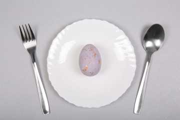 Easter gray golden spotty egg on gray background. Easter concept. Minimalism. Top view, flat lay