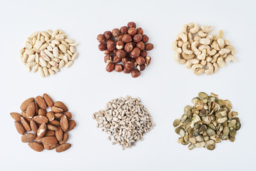peanuts, cashews, hazelnuts, almonds, pumpkin seeds and sunflower seeds on a white isolated background