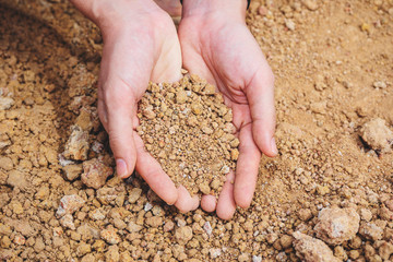 Hands holding soil in hand with natural concept.