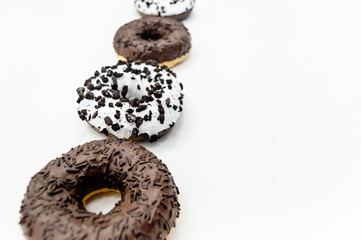Donuts  with chocolate glazed with sprinkles donuts isolated on white black abstract background