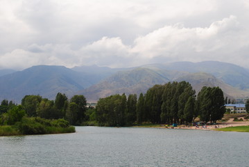 landscape with sea, mountains, trees and clouds
