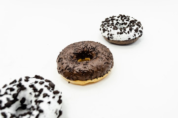 Donuts  with chocolate glazed with sprinkles donuts isolated on white black abstract background