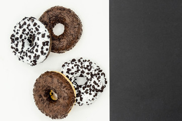Donuts  with chocolate glazed with sprinkles donuts isolated on white black abstract background