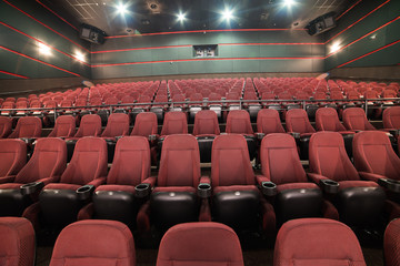 Naklejka premium Empty cinema auditorium. Mock up.part of a theatre, or similar building, where the people who are watching and listening sit