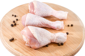 chicken legs on wooden board isolated on white background