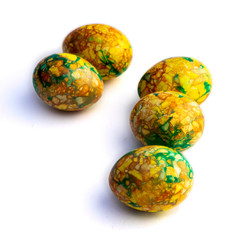 handmade yellow green easter eggs painted marbled over white background