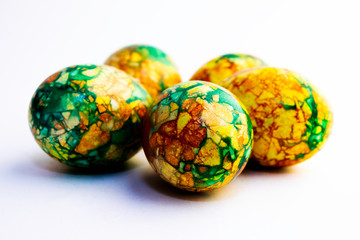 handmade yellow green easter eggs painted marbled over white background