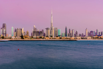 Obraz premium Futuristic Skyscraper buildings view from beach island with blue waterfront and twilight sky background