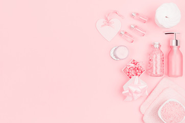 Natural skin care products, accessories for bathroom - cream, salt, essential oil, soap, towel, perfume, pearls, gift, box, bottles, heart, bowl on pink background.