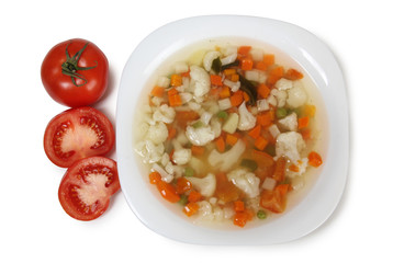 Porcelain plate with vegetable soup on white background