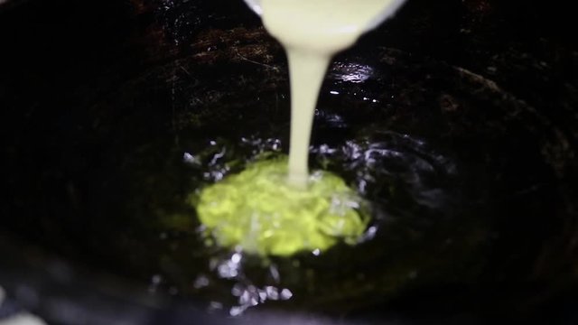 Frying local cake in oil and it is named pitha. Preparing a local dessert for Asian countries likes Bangladesh, India, Nepal etc. And this video is with sound.
