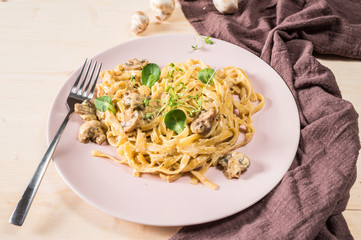 Pasta with mushroom cream sauce on wooden table 