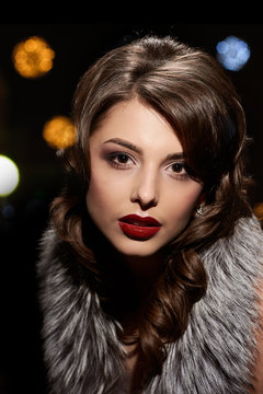 Retro portrait of young beautiful woman with fur collar, background with different highlights