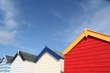 Colorful English beach huts against a blue sky