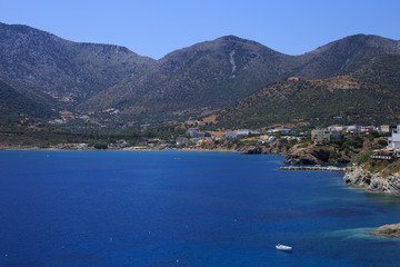 Naklejka premium Sea Bay of resort village Bali. Views of mountain, shore, washed by waves and sun loungers. Bali, Rethymno, Crete, Greece