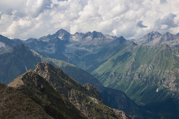 Panorama of mountains scene with dramatic cloudy sky in national park of Dombay
