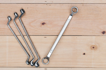 Wrench tool on wooden background.
