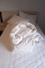 a white corrugated blanket and two pillows on the bed
