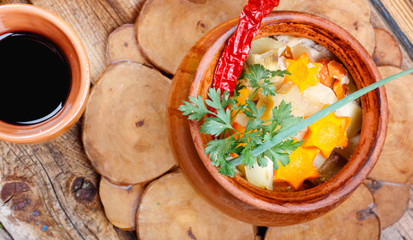 Traditional rustic home  gulyas, with raw vegetables and spices in clay pots on  wooden table.