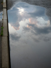 Dramatic cloud reflection on plash on the street
