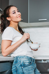 The beautiful smiling asian girl slim young woman having light  breakfast in her kitchen