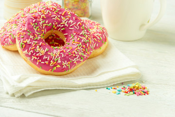 Donut on a kitchen towel and on a wooden table. Photo of sweets.