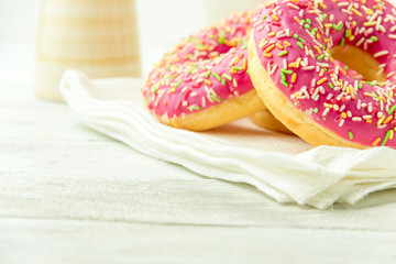 Donut on a kitchen towel and on a wooden table. Photo of sweets with copyspace.