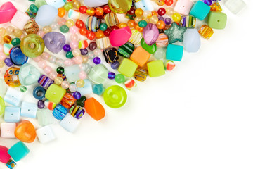 An overhead photo of many different beads, shot from the top on a white background with copy space