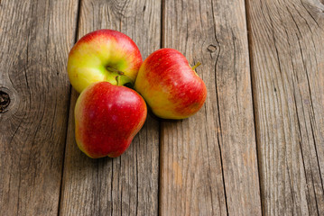 three apples on old wooden background