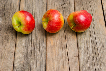three apples on old wooden background