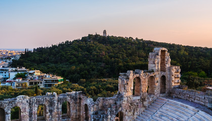 Fototapeta na wymiar View of Odeon of Herodes Atticus theater on Acropolis hill, Athens, Greece, overlooking the city and hill of Muses or Philpppapou at sunset
