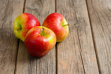 three apples on old wooden background