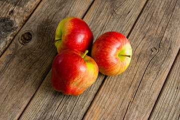three apples on old wooden background