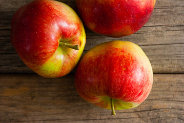 Fototapeta na wymiar three apples on old wooden background