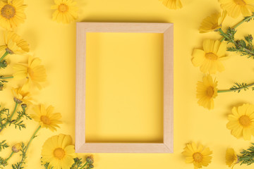 Flowers composition. Chamomile flowers with photo frame on yellow background. Spring, summer concept. Flat lay, top view, copy space